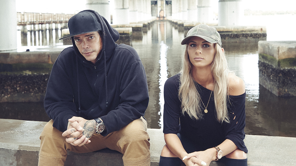 Dopesick Nation's Frankie and Allie sitting next to each other on a concrete ledge. Addiction treatment on TV