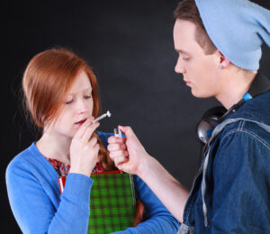 a teen boy lighting a joint for a teen girl