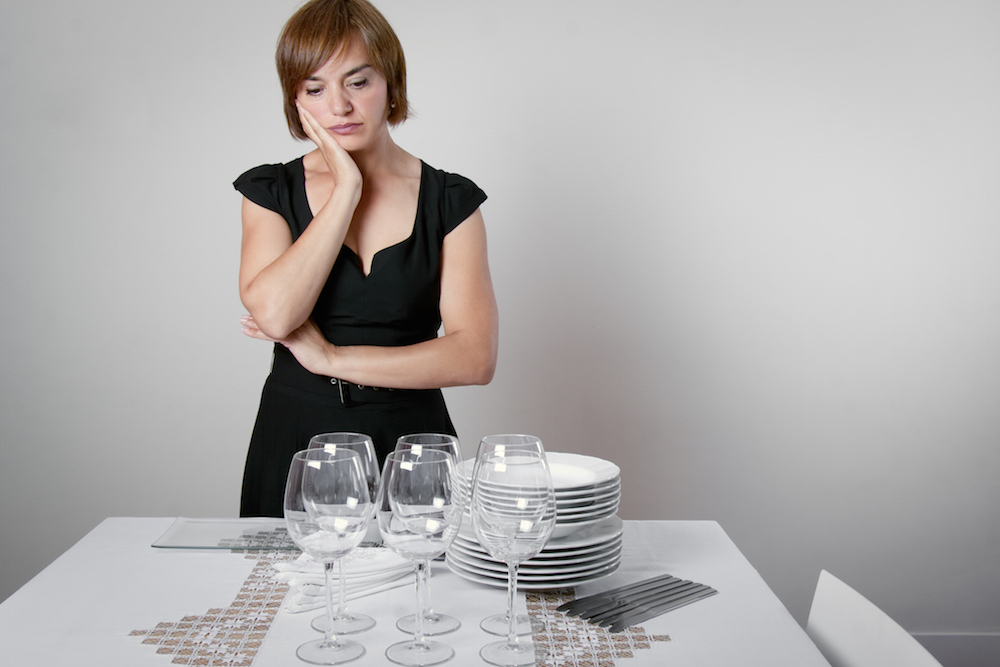 Worried woman standing in front of a table thinking about relative with eating disorder