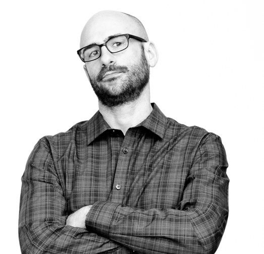 Black and white image of Victor Yocco, the author, with a beard, glasses, plaid long-sleeved shirt. Arms crossed.