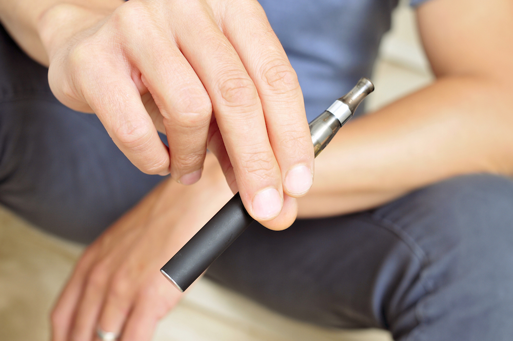 a teen vaping with an e-cigarette