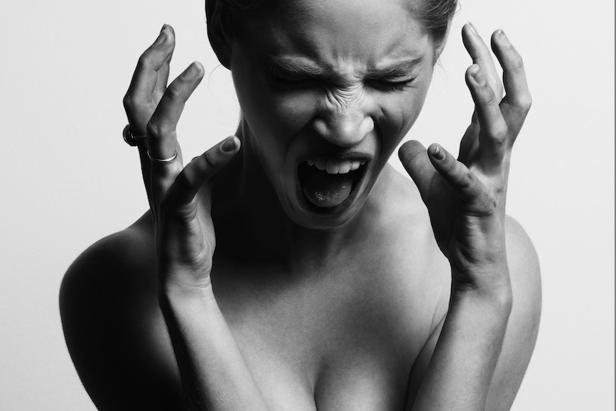 Black and white image of shouting woman, angry expression, addicted to anger