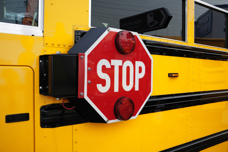 Side view of a school bus and its the stop signal.