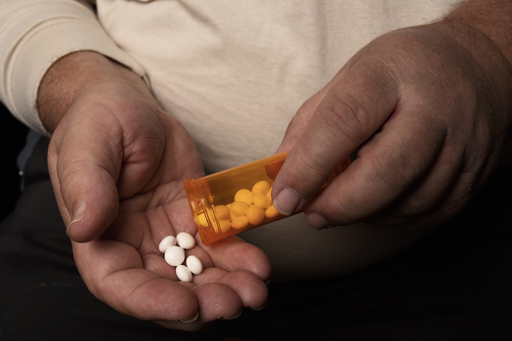 person holding handful of counterfeit oxy