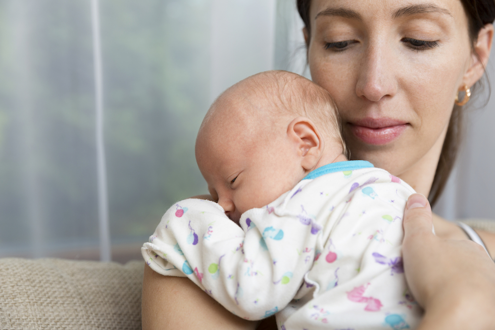 woman with postpartum depression holding her baby
