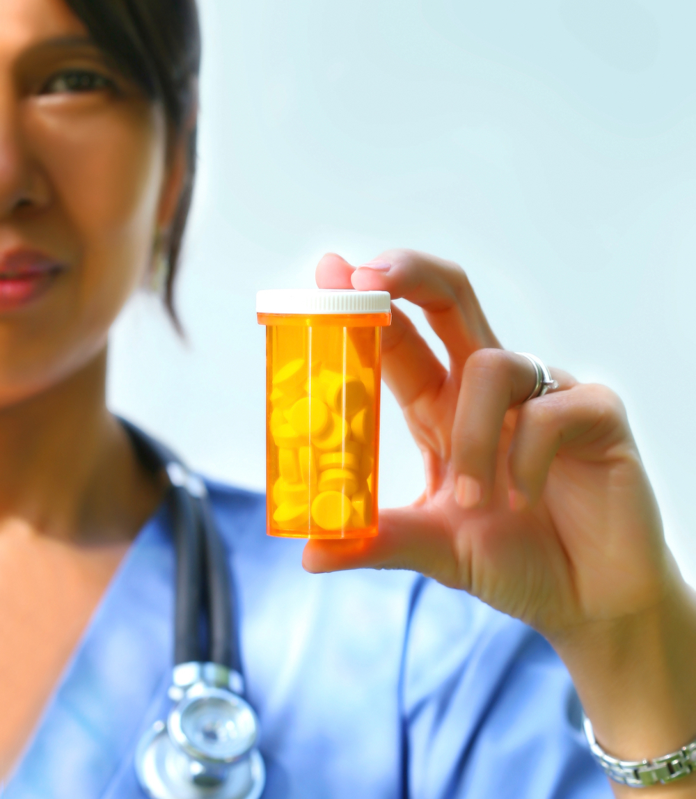 New York doctor holding a bottle of prescription opioids
