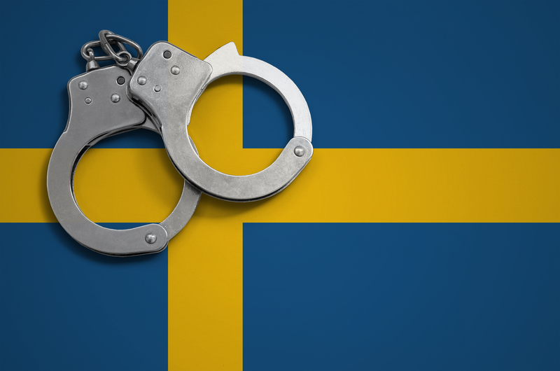 Sweden flag and police handcuffs. The concept of crime and offenses in the country.