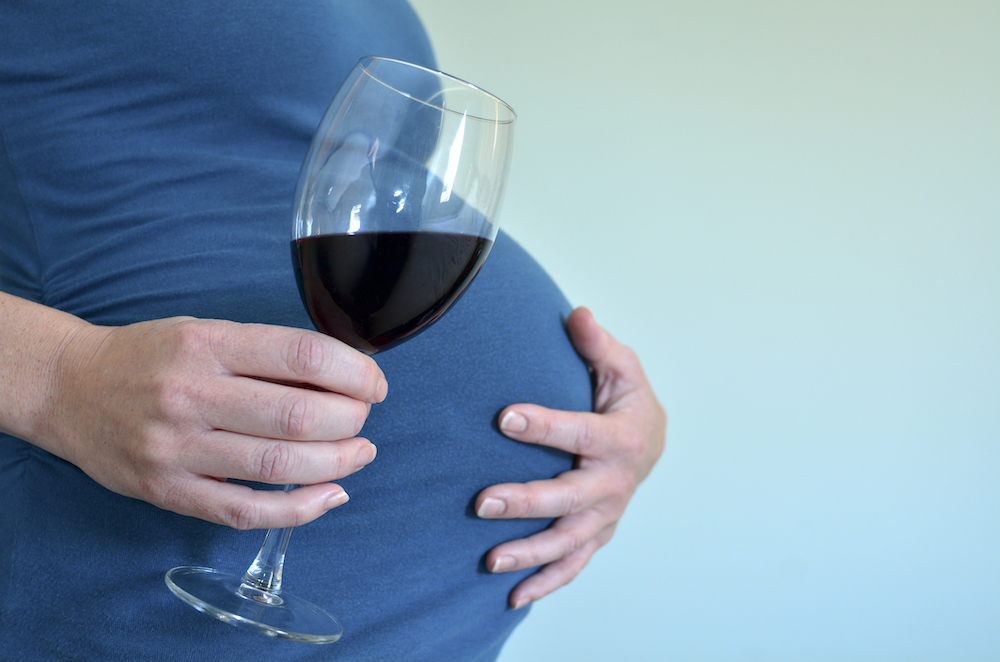 pregnant woman holding a glass of wine