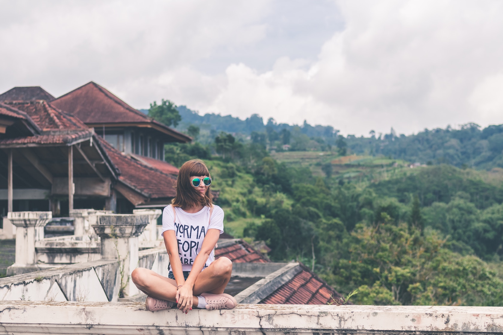 Woman sitting on a ledge, sober travel