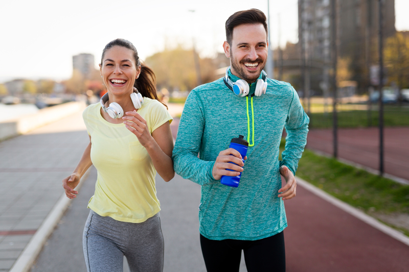 man and woman smiling and jogging