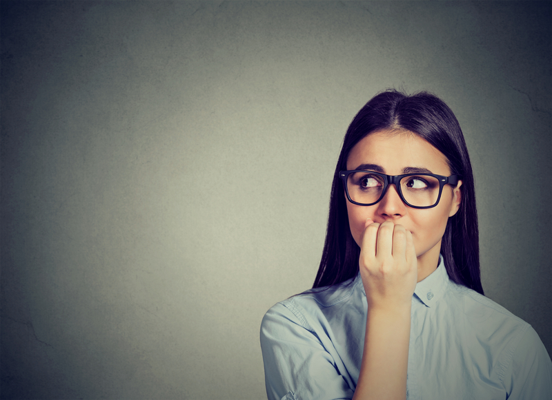 Woman biting her nails, nervous and craving.