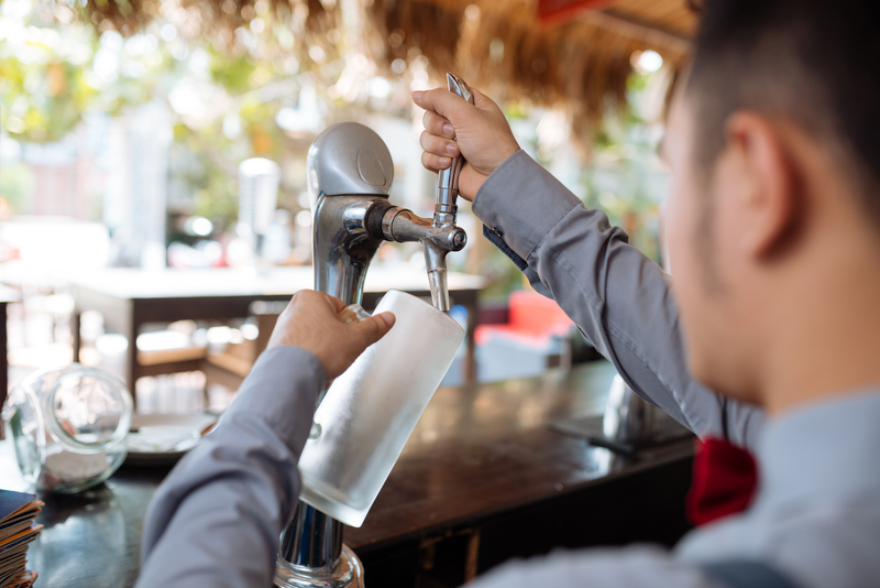 barman pouring draft beer