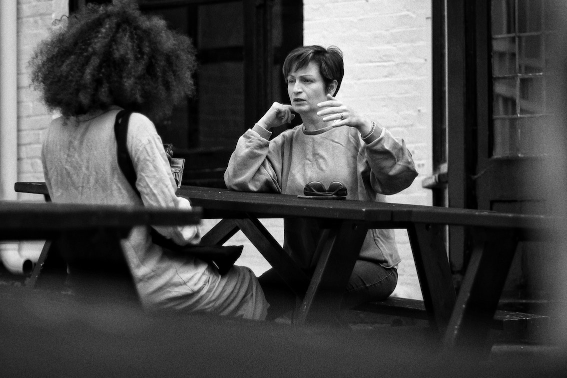 Two women talking, seriously. Black and white photo.