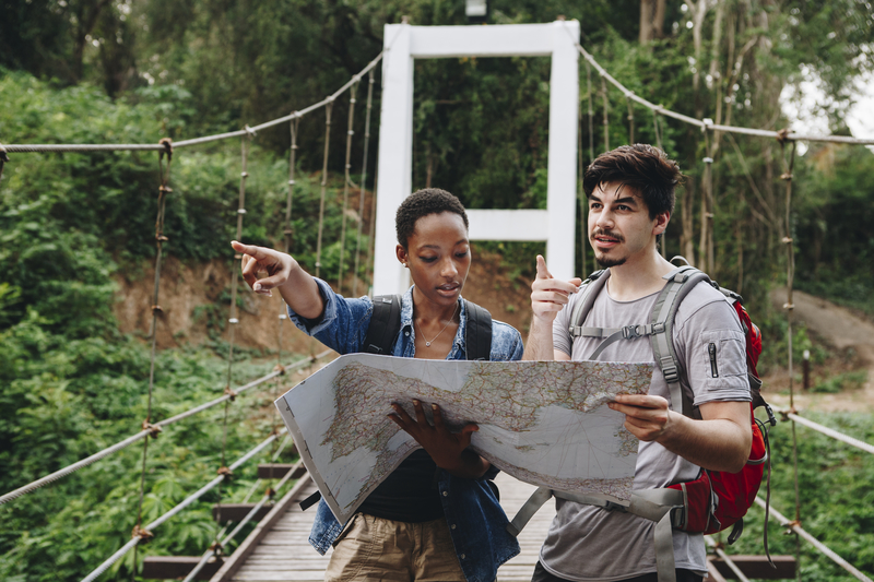 Woman and man on bridge, looking at map.
