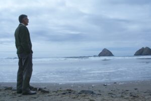 Man standing alone, looking out over the water