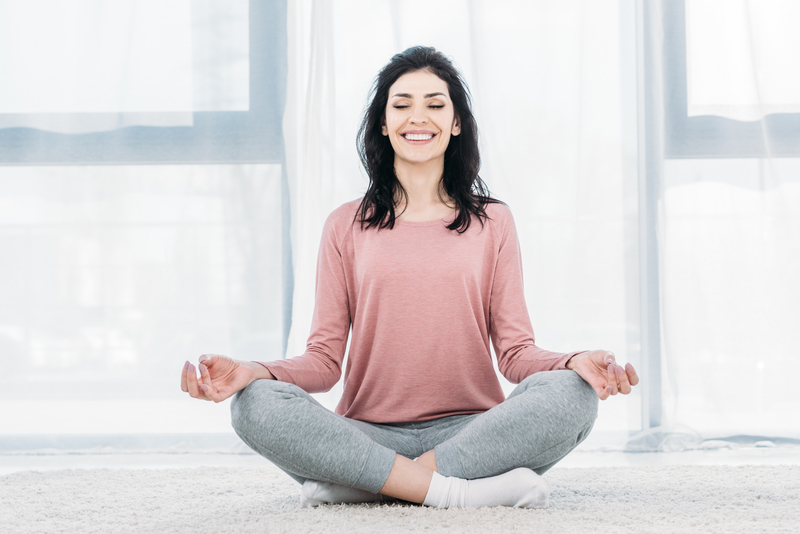 Woman sitting cross-legged and smiling