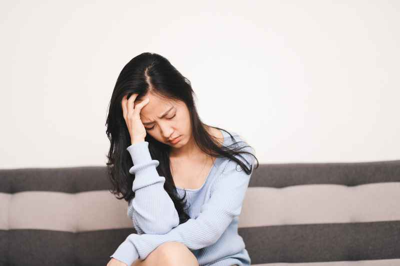 Woman sitting alone, head in hand, depressed or sad